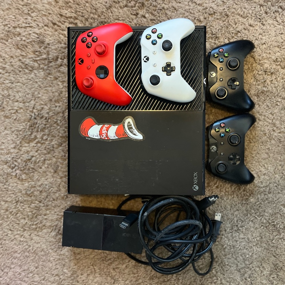Microsoft Console with Red, White, and Black Controllers